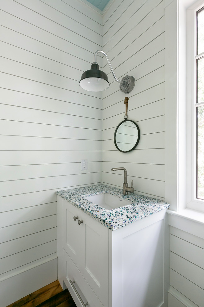 Inspiration for a large beach style powder room in Charleston with white walls, dark hardwood floors, an undermount sink, shaker cabinets, white cabinets, engineered quartz benchtops, beige floor and multi-coloured benchtops.