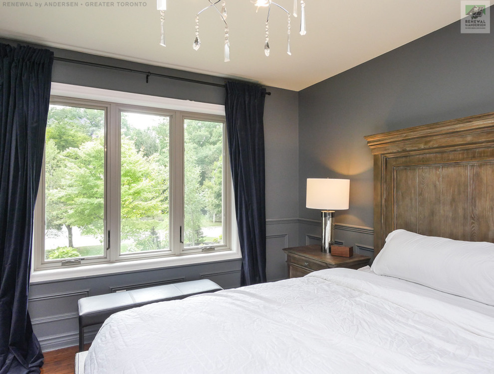 Imagen de dormitorio pequeño sin chimenea con paredes azules, suelo de madera en tonos medios y boiserie