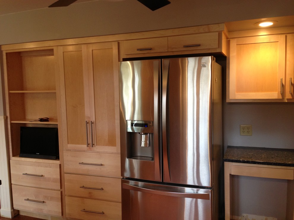 Enclosed kitchen - small transitional u-shaped medium tone wood floor enclosed kitchen idea in Chicago with a double-bowl sink, shaker cabinets, light wood cabinets, quartzite countertops, stainless steel appliances and a peninsula
