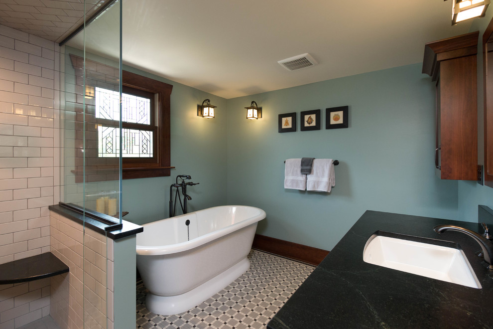 Photo of a mid-sized arts and crafts master bathroom in Detroit with shaker cabinets, dark wood cabinets, a freestanding tub, an alcove shower, a two-piece toilet, black and white tile, porcelain tile, green walls, mosaic tile floors, an undermount sink and soapstone benchtops.