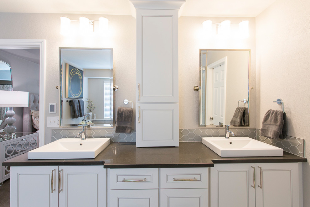 Photo of a mid-sized transitional master bathroom in Denver with recessed-panel cabinets, white cabinets, a freestanding tub, an alcove shower, a two-piece toilet, white tile, porcelain tile, grey walls, porcelain floors, a vessel sink, engineered quartz benchtops, grey floor and a hinged shower door.