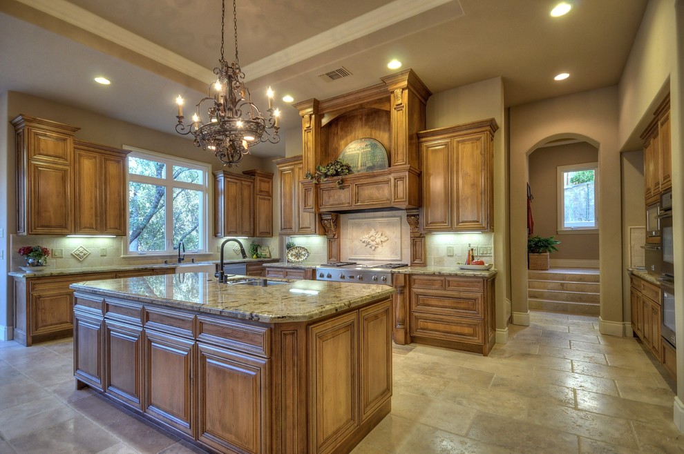 This is an example of a traditional kitchen in Sacramento with granite benchtops, travertine floors and travertine splashback.