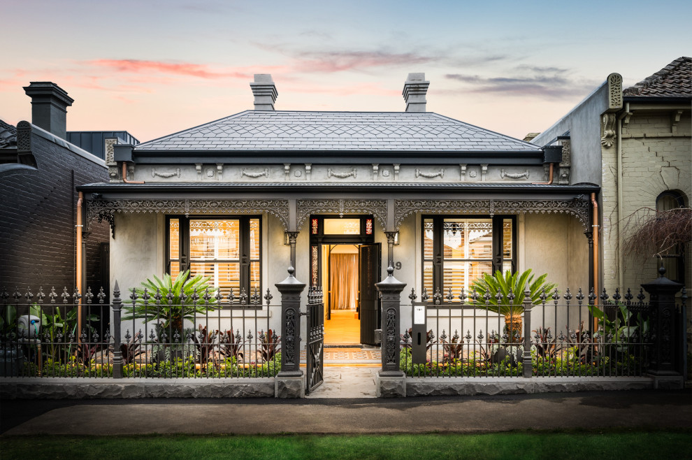 This is an example of a traditional one-storey white house exterior in Melbourne with a hip roof and a tile roof.