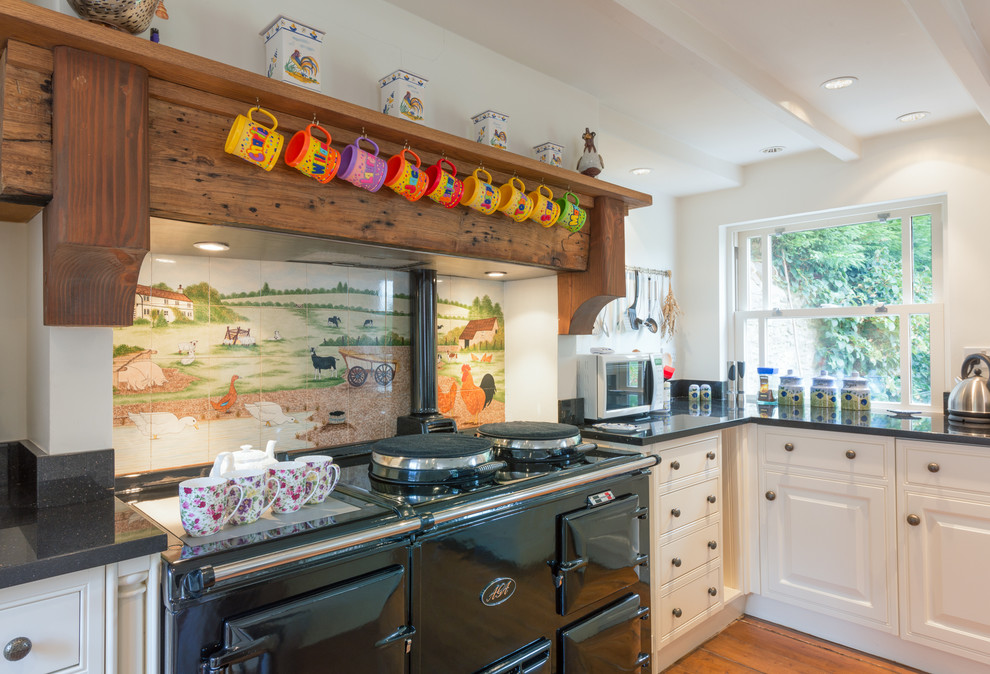 Inspiration for a large traditional u-shaped eat-in kitchen in Devon with an undermount sink, shaker cabinets, distressed cabinets, granite benchtops, multi-coloured splashback, ceramic splashback, coloured appliances and medium hardwood floors.