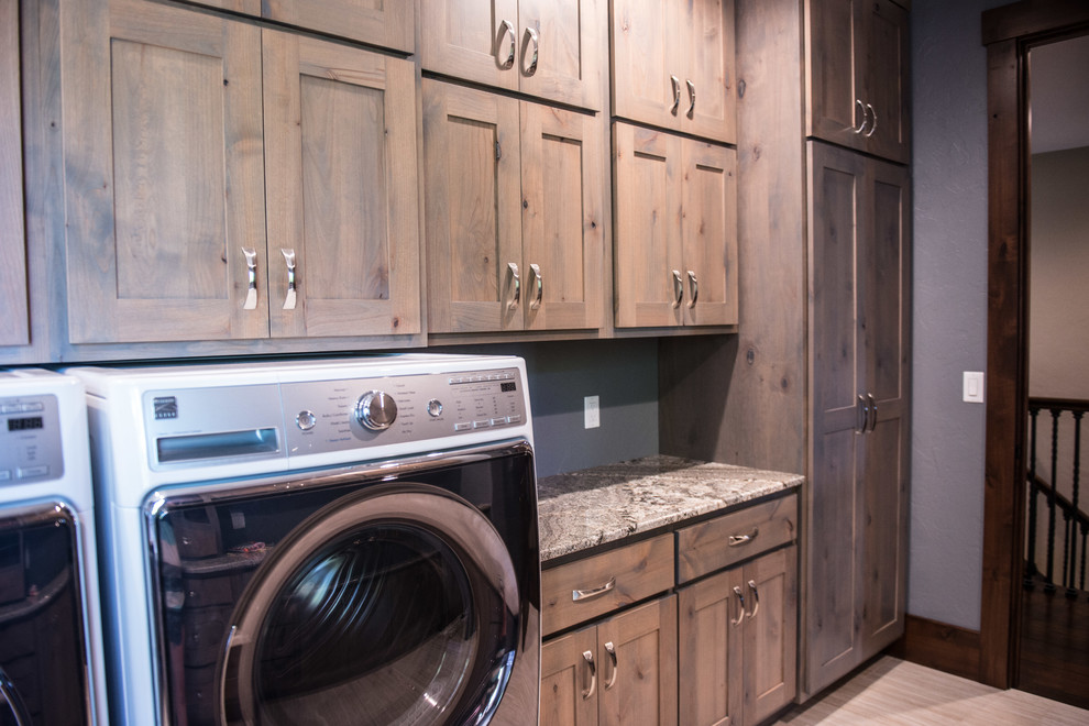 Inspiration for an expansive country u-shaped utility room in Other with an undermount sink, flat-panel cabinets, light wood cabinets, granite benchtops, blue walls, a side-by-side washer and dryer, grey floor and multi-coloured benchtop.