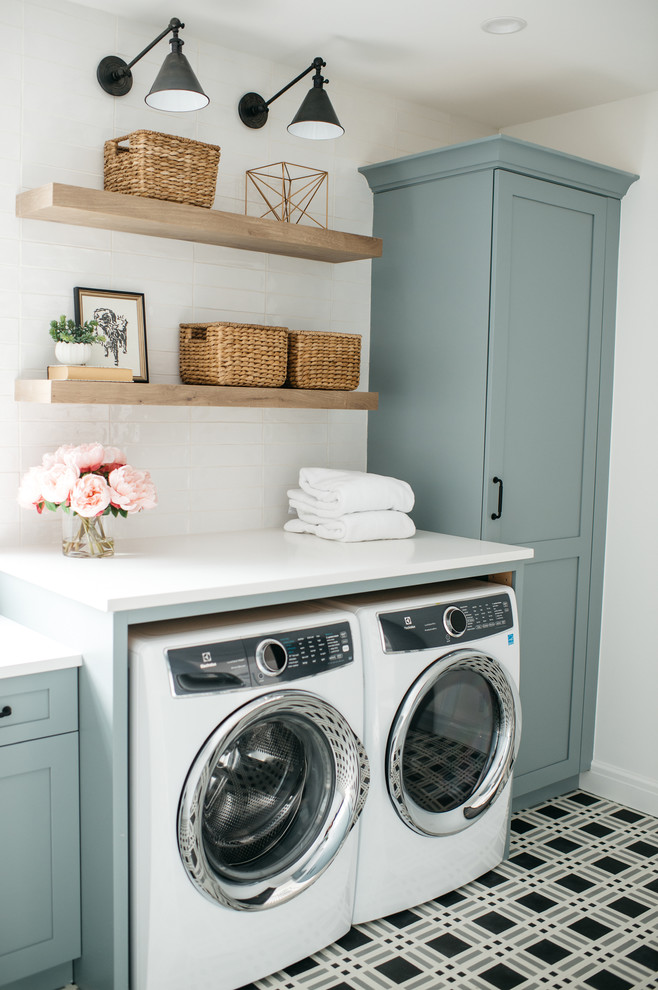 Country single-wall dedicated laundry room in Detroit with shaker cabinets, blue cabinets, white walls, a side-by-side washer and dryer, multi-coloured floor and white benchtop.