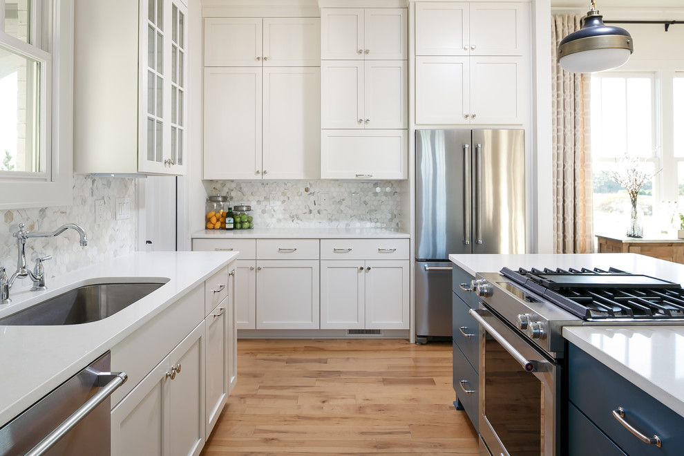 Mid-sized transitional l-shaped eat-in kitchen in Louisville with a single-bowl sink, shaker cabinets, white cabinets, quartz benchtops, white splashback, stone tile splashback, stainless steel appliances, with island and medium hardwood floors.