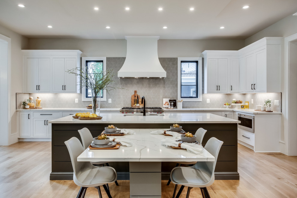 Eat-in kitchen - transitional u-shaped medium tone wood floor and brown floor eat-in kitchen idea in DC Metro with an undermount sink, shaker cabinets, white cabinets, quartz countertops, gray backsplash, stainless steel appliances and an island