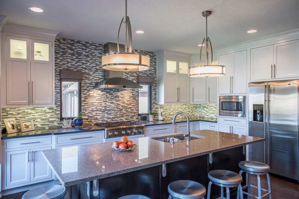 Example of a large transitional l-shaped dark wood floor open concept kitchen design with a double-bowl sink, beaded inset cabinets, white cabinets, granite countertops, multicolored backsplash, matchstick tile backsplash, stainless steel appliances and an island