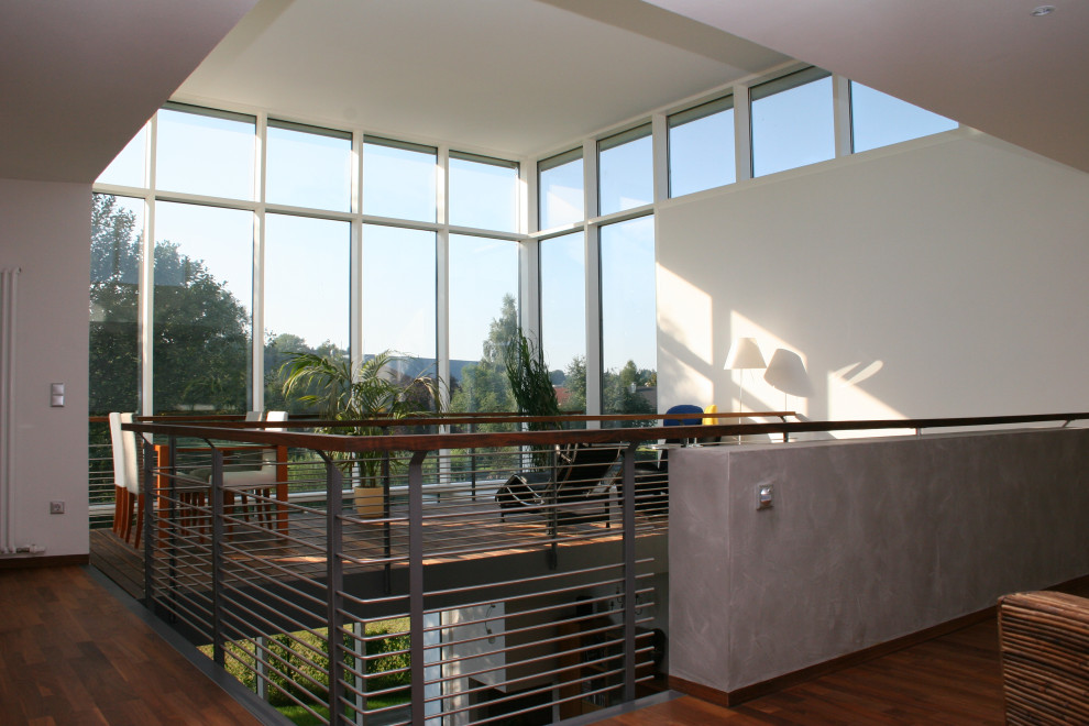 Geräumiger Moderner Wintergarten mit dunklem Holzboden, normaler Decke und braunem Boden in Sonstige