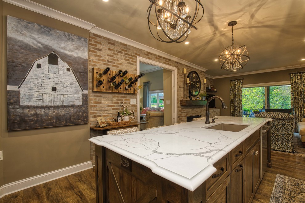 Inspiration for a large country eat-in kitchen in Louisville with a farmhouse sink, white cabinets, granite benchtops, white splashback, stainless steel appliances, vinyl floors, with island, brown floor and white benchtop.