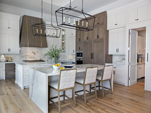 Bright modern kitchen with white shaker RTA cabinets, warm wood pantry wall, marble waterfall island, and black linear chandeliers.