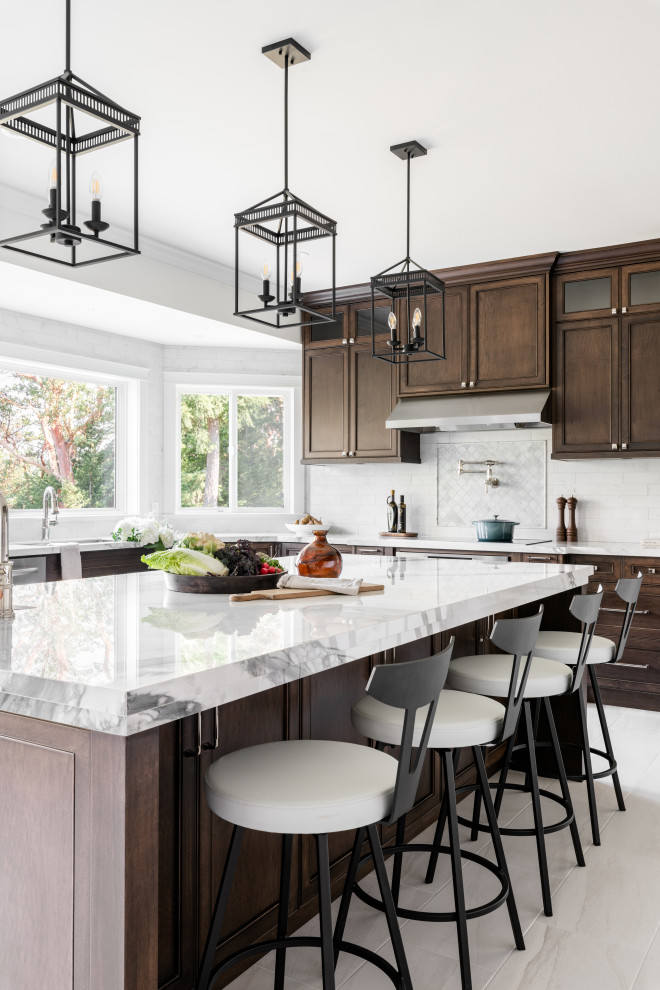 Large transitional u-shaped porcelain tile and white floor open concept kitchen photo in Vancouver with an undermount sink, recessed-panel cabinets, dark wood cabinets, quartz countertops, white backsplash, ceramic backsplash, stainless steel appliances, an island and white countertops