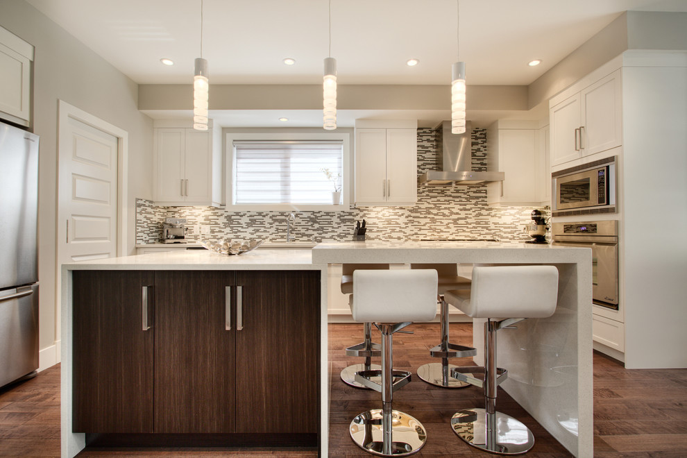 This is an example of a contemporary kitchen in Calgary with flat-panel cabinets and stainless steel appliances.