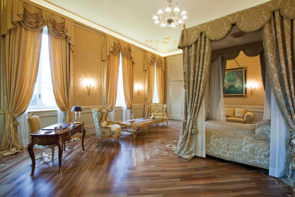 This is an example of an expansive traditional master bedroom in Milan with light hardwood floors and yellow walls.