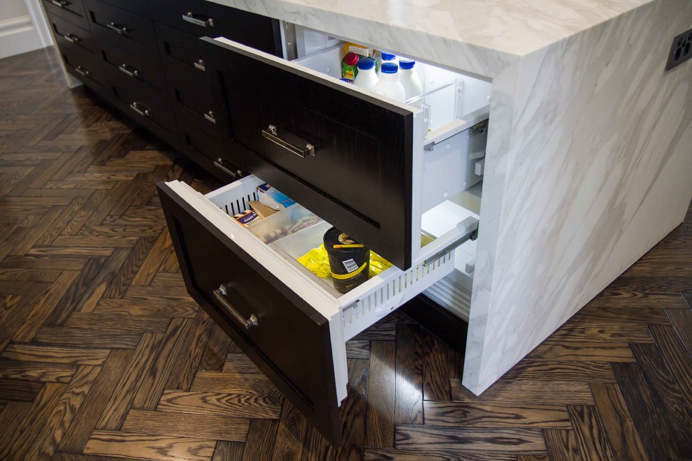 Inspiration for a large traditional l-shaped open plan kitchen in Melbourne with shaker cabinets, marble benchtops, stone slab splashback, dark hardwood floors and multiple islands.