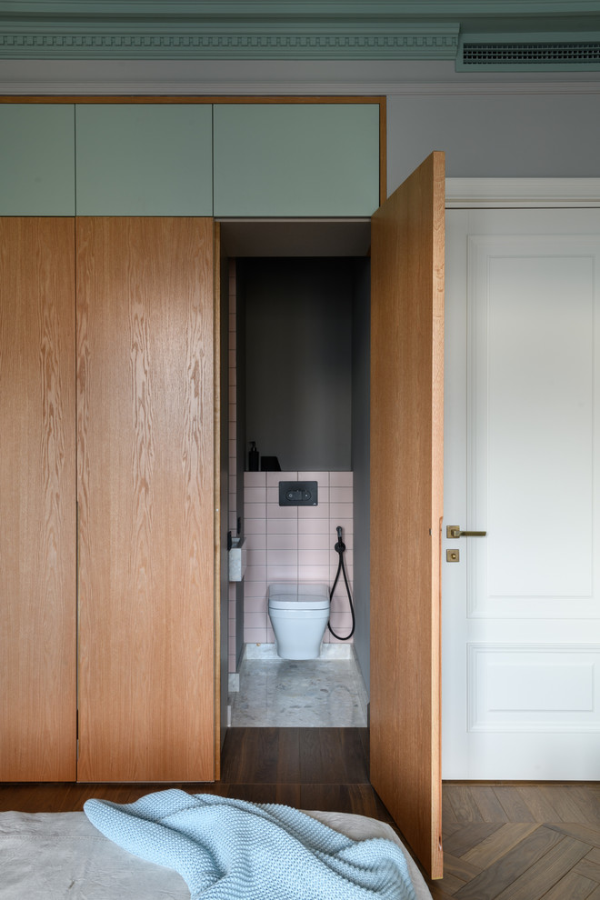 Design ideas for a mid-sized modern powder room in Other with a wall-mount toilet, pink tile, grey walls, terrazzo floors and grey floor.