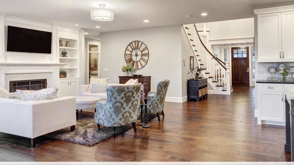 Inspiration for a mid-sized transitional formal open concept living room in Denver with white walls, dark hardwood floors, a standard fireplace, a plaster fireplace surround, a wall-mounted tv and brown floor.