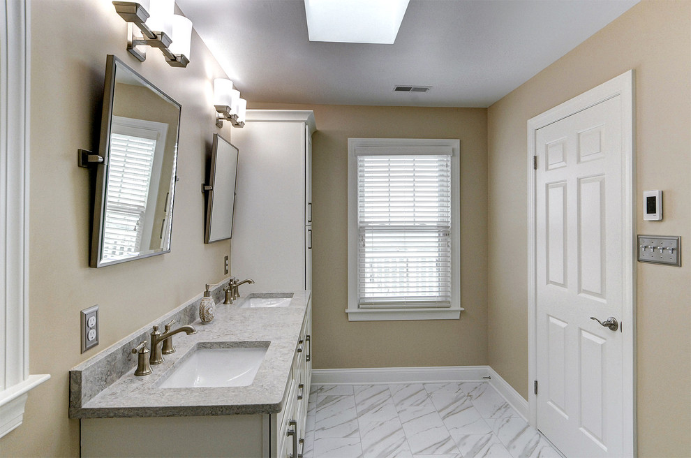 Photo of a mid-sized transitional master wet room bathroom in Philadelphia with shaker cabinets, a two-piece toilet, white tile, porcelain tile, beige walls, porcelain floors, an undermount sink, engineered quartz benchtops, white floor, a hinged shower door and beige benchtops.