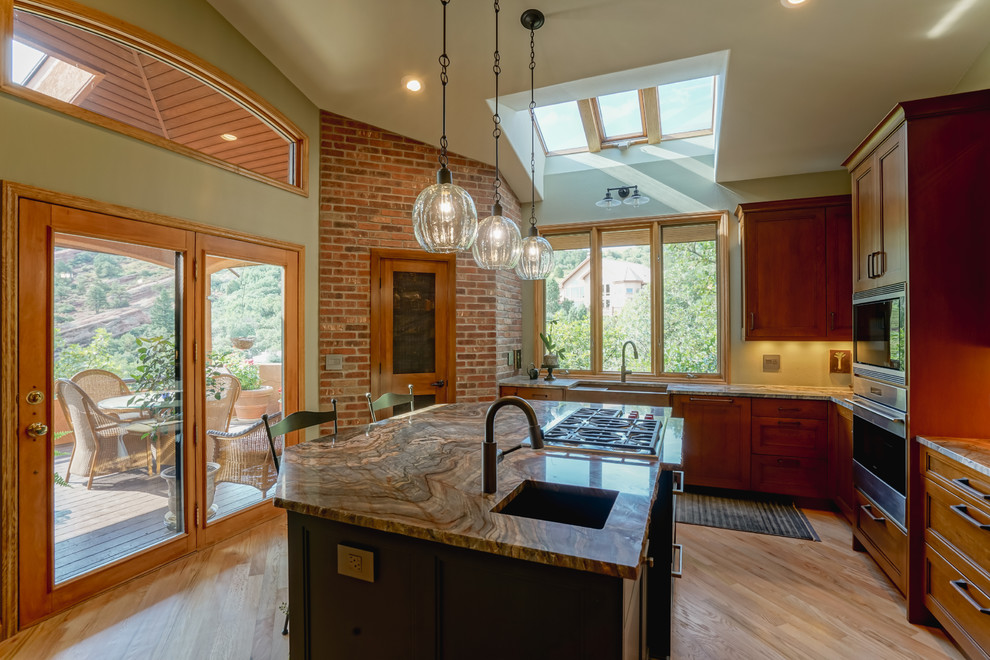 Example of a mid-sized transitional medium tone wood floor and brown floor kitchen design in Denver with a farmhouse sink, recessed-panel cabinets, medium tone wood cabinets, granite countertops, paneled appliances and an island