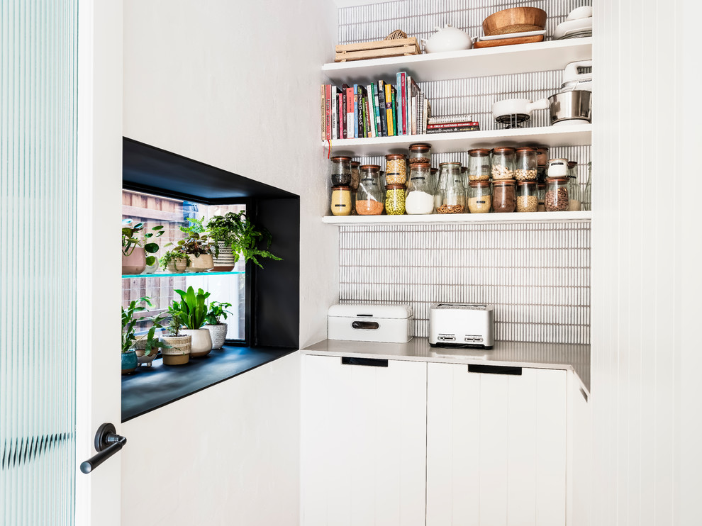 Inspiration for a mid-sized contemporary u-shaped kitchen pantry in Sydney with white cabinets, quartz benchtops, grey splashback, ceramic splashback, medium hardwood floors, with island, brown floor and grey benchtop.