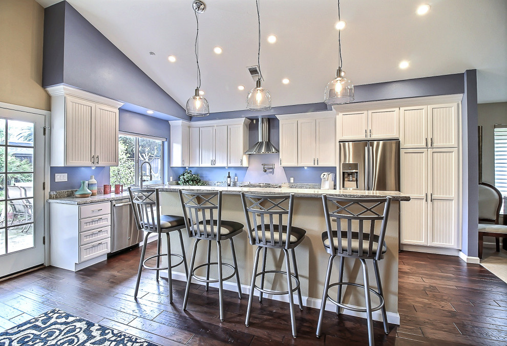 Immagine di una grande cucina contemporanea con lavello sottopiano, ante bianche, paraspruzzi blu, elettrodomestici in acciaio inossidabile, parquet scuro, pavimento marrone e top grigio