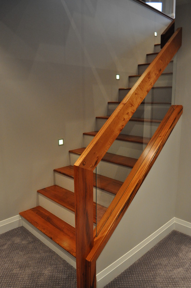 Mid-sized contemporary wood straight staircase in Calgary with open risers.