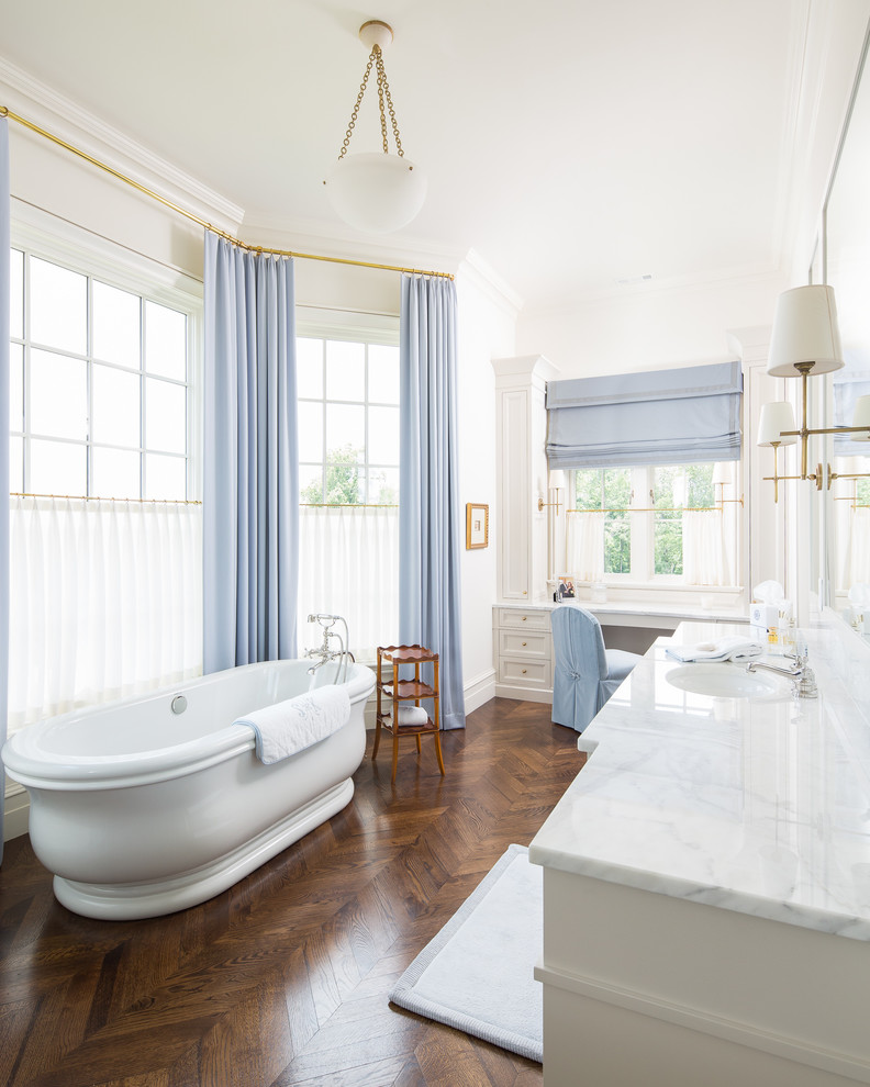 Large traditional kids bathroom in Atlanta with recessed-panel cabinets, white cabinets, a freestanding tub, an alcove shower, a two-piece toilet, beige walls, medium hardwood floors, an undermount sink, marble benchtops and a hinged shower door.