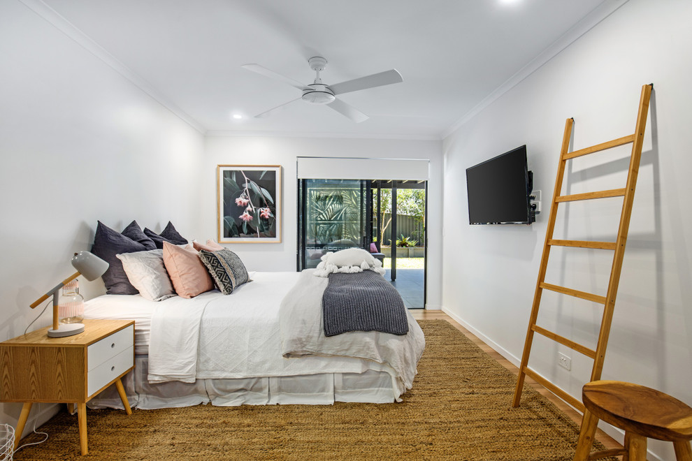 Design ideas for a large contemporary guest bedroom in Sunshine Coast with white walls, medium hardwood floors and brown floor.