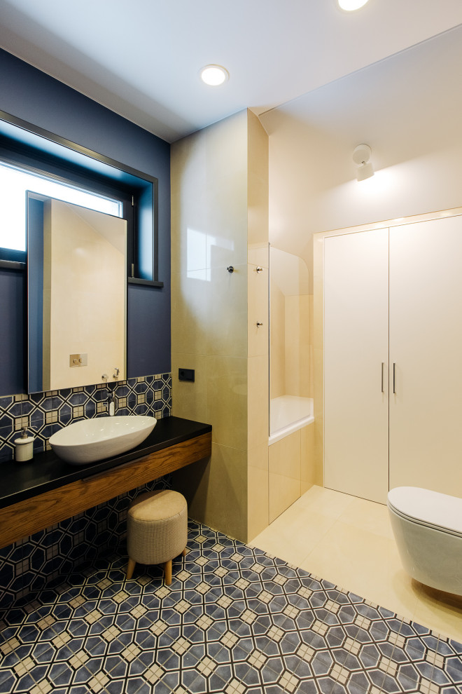 Aménagement d'une petite salle de bain contemporaine avec WC suspendus, des carreaux de porcelaine, un sol en carrelage de porcelaine, un lavabo posé, un plan de toilette noir, une fenêtre, meuble simple vasque et meuble-lavabo suspendu.
