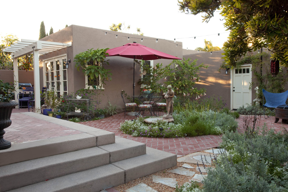 Photo of an arts and crafts backyard patio in San Diego with brick pavers.