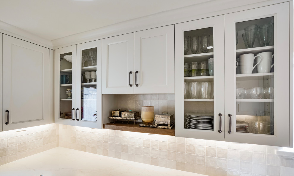 Mid-sized transitional u-shaped kitchen in San Francisco with shaker cabinets, white cabinets, quartz benchtops, white splashback, terra-cotta splashback, stainless steel appliances and white benchtop.