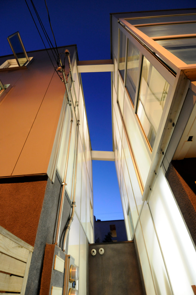 Kleine, Zweistöckige Moderne Doppelhaushälfte mit Glasfassade, weißer Fassadenfarbe, Pultdach, Misch-Dachdeckung und grauem Dach in Los Angeles