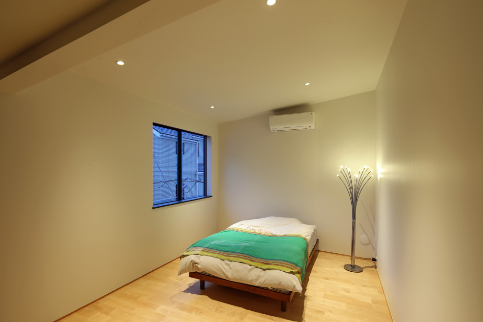 Diseño de dormitorio principal y blanco moderno de tamaño medio sin chimenea con paredes blancas, suelo de madera clara, papel pintado y papel pintado