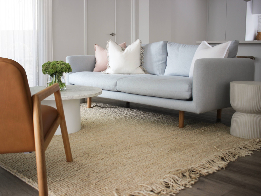 Photo of a mid-sized contemporary open concept living room in Sydney with white walls, light hardwood floors, a standard fireplace, no tv and beige floor.
