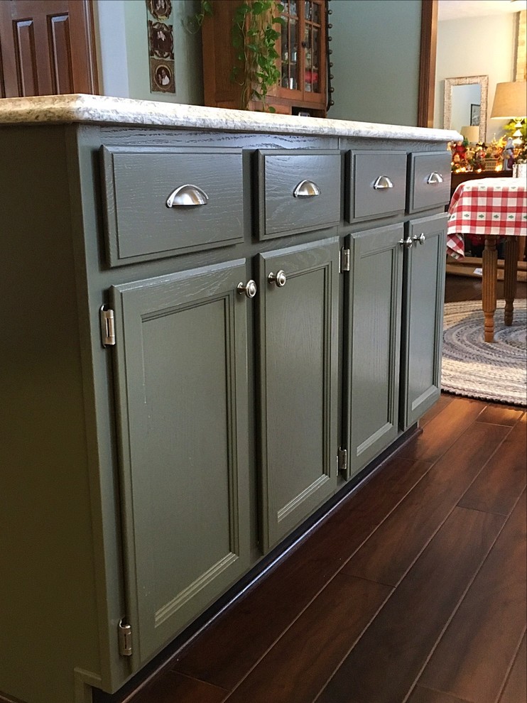 Enclosed kitchen - mid-sized transitional u-shaped medium tone wood floor enclosed kitchen idea with an undermount sink, white cabinets, quartz countertops, white backsplash, subway tile backsplash, stainless steel appliances and an island