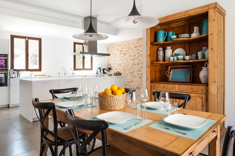 Inspiration for a large mediterranean open plan dining in Madrid with white walls and grey floor.