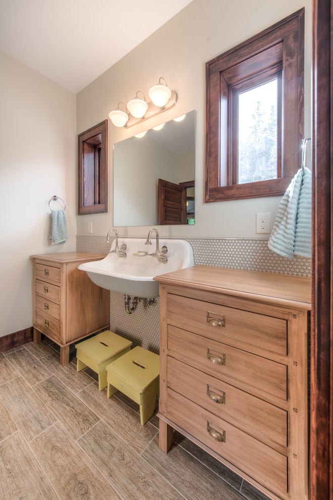 Photo of a transitional bathroom in Denver with a trough sink, medium wood cabinets, wood benchtops, beige tile and flat-panel cabinets.