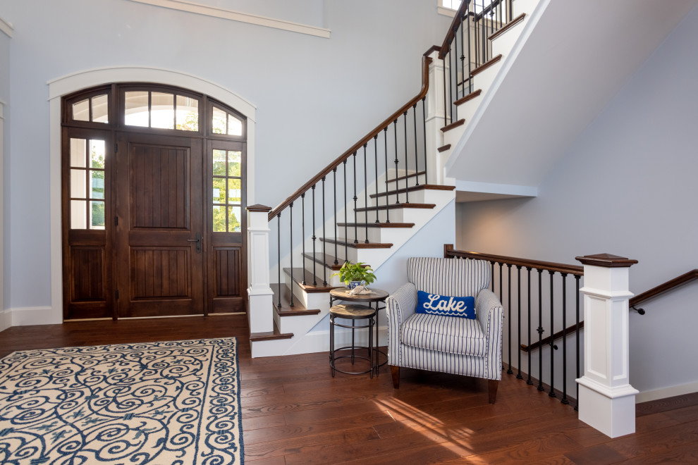Large classic front door in Other with blue walls, dark hardwood flooring, a dark wood front door and brown floors.