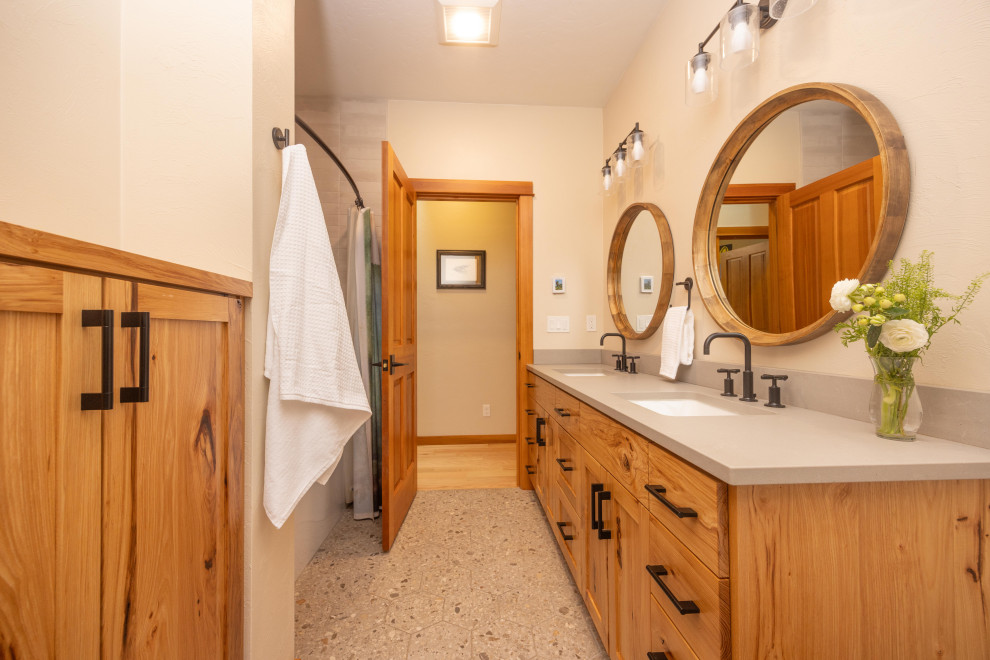 Alcove bathtub - mid-sized rustic kids' gray tile and porcelain tile terrazzo floor, gray floor and double-sink alcove bathtub idea with shaker cabinets, medium tone wood cabinets, a one-piece toilet, beige walls, an undermount sink, quartz countertops, gray countertops, a niche and a freestanding vanity