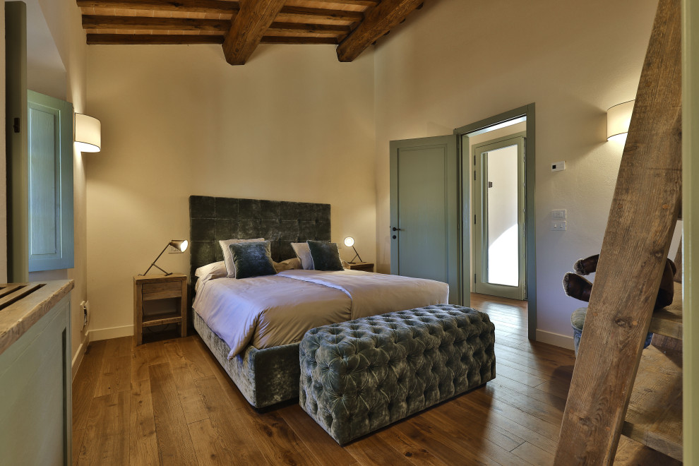 フィレンツェにある広いカントリー風のおしゃれな主寝室 (黄色い壁、塗装フローリング、茶色い床、表し梁) のインテリア