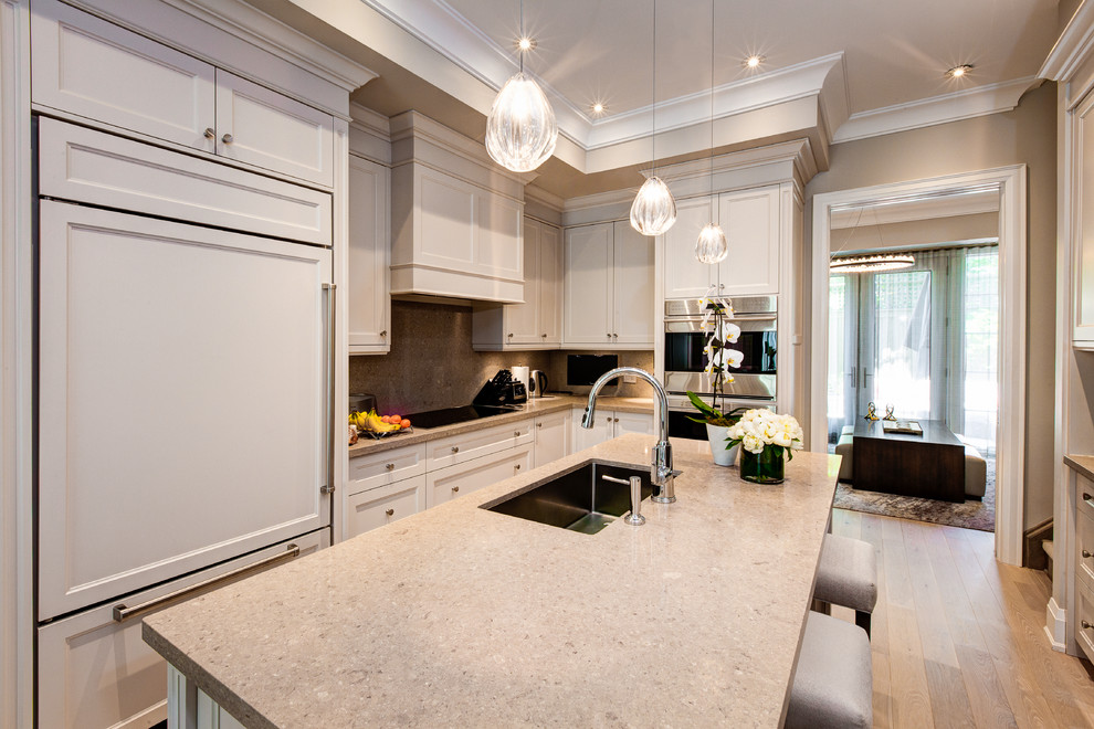 Inspiration for a mid-sized transitional l-shaped light wood floor and gray floor eat-in kitchen remodel in Toronto with a single-bowl sink, recessed-panel cabinets, quartz countertops, stainless steel appliances, an island, white cabinets, multicolored backsplash and stone slab backsplash