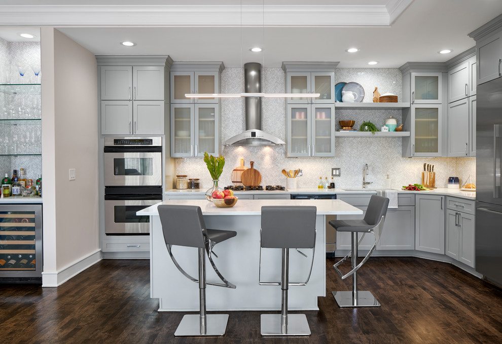 Photo of a transitional kitchen in Chicago with an undermount sink, glass-front cabinets, grey cabinets, multi-coloured splashback, stainless steel appliances, dark hardwood floors, with island, brown floor and white benchtop.