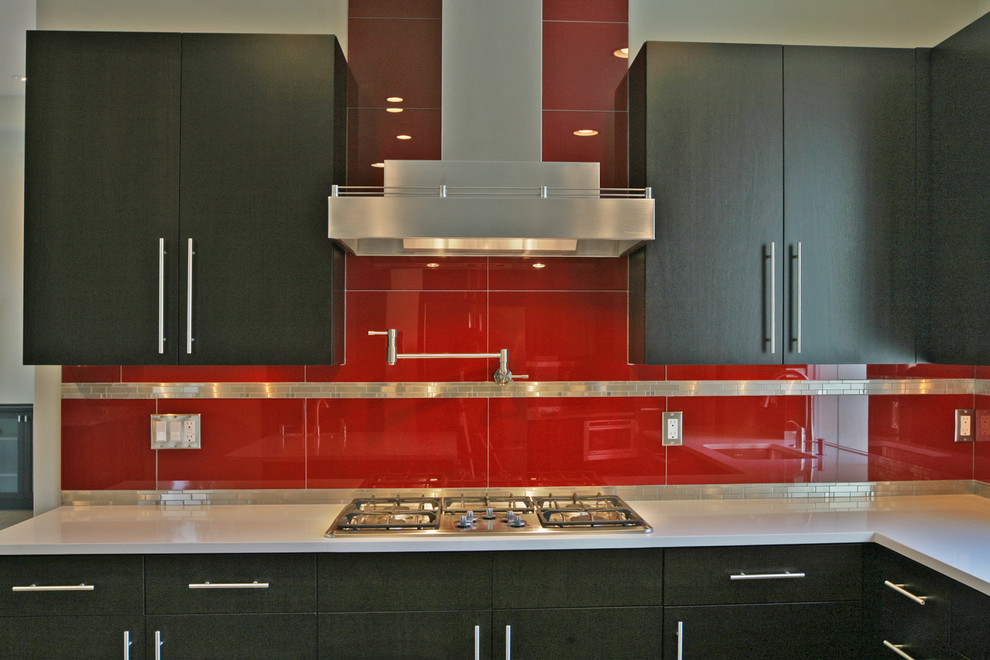 Photo of a large modern open plan kitchen in Portland with an undermount sink, flat-panel cabinets, dark wood cabinets, quartz benchtops, red splashback, ceramic splashback, stainless steel appliances, light hardwood floors and with island.