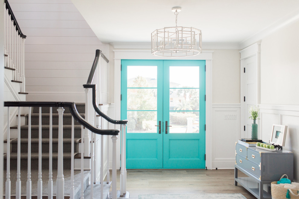 Photo of a beach style foyer in Charleston with white walls, light hardwood floors, a double front door and a blue front door.