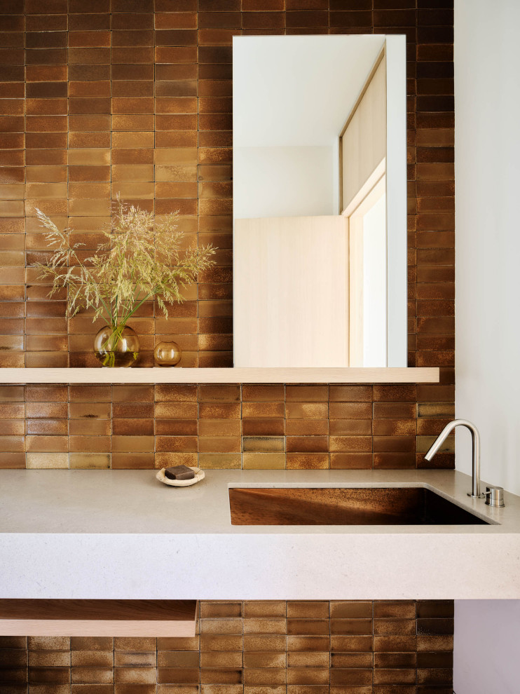 Expansive modern powder room in San Francisco with a floating vanity, brown tile, metal tile, beige benchtops and beige cabinets.