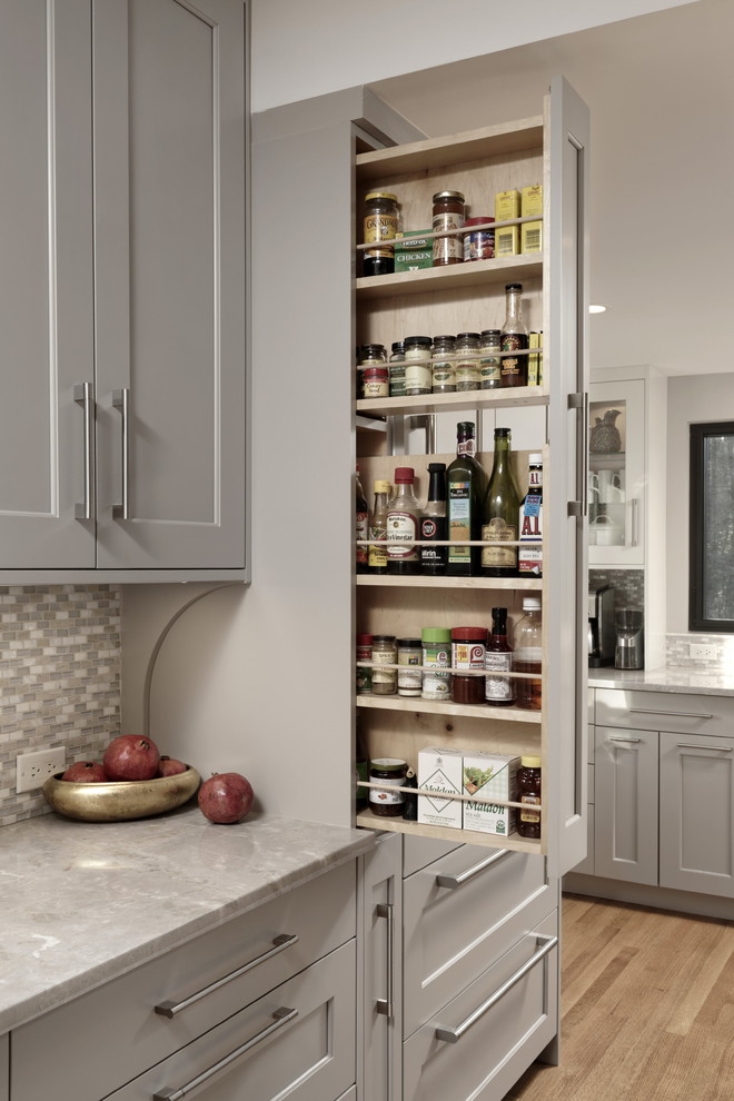 Design ideas for a large transitional kitchen pantry in DC Metro with an undermount sink, shaker cabinets, grey cabinets, quartzite benchtops, grey splashback, mosaic tile splashback, stainless steel appliances, medium hardwood floors, brown floor and grey benchtop.