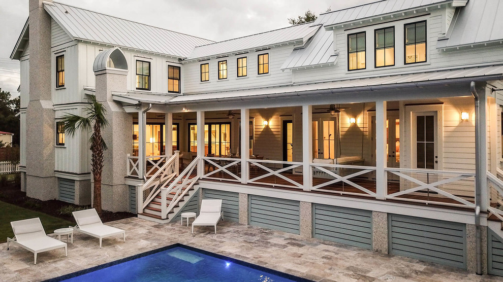 This is an example of a large beach style two-storey white house exterior in Charleston with mixed siding, a gable roof and a metal roof.