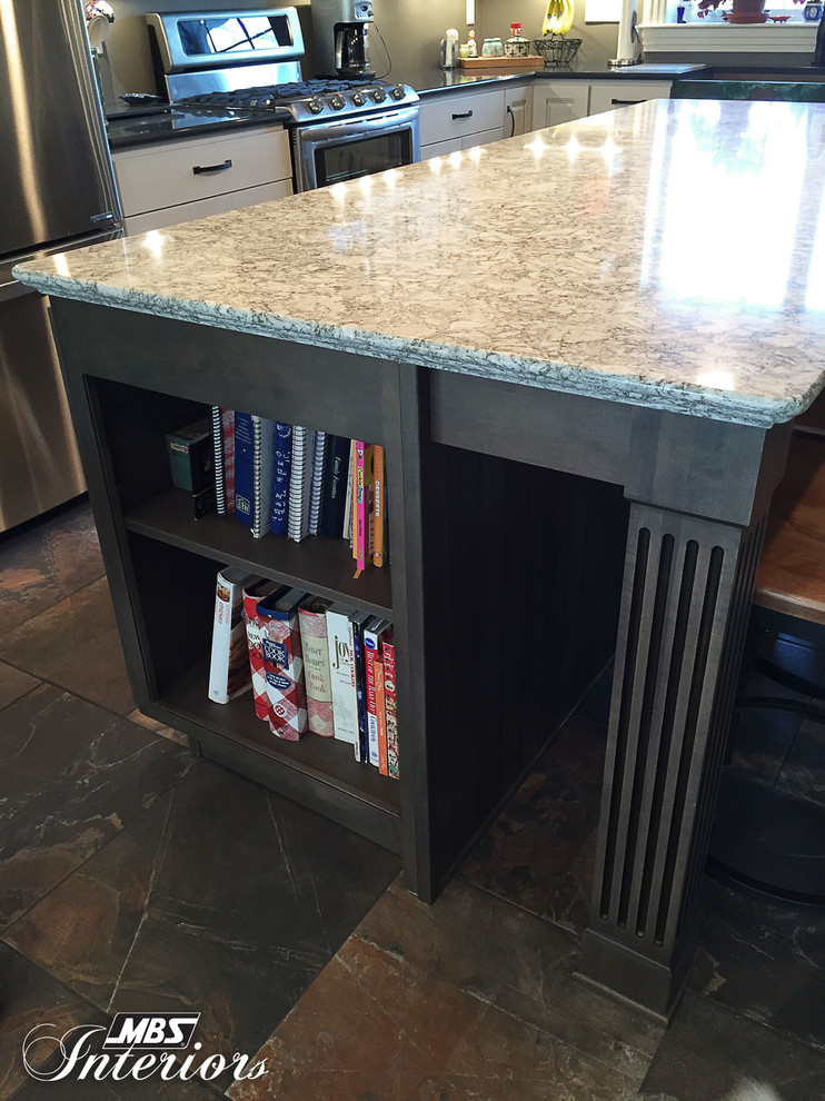 Example of a transitional l-shaped home design design with a farmhouse sink, white cabinets, quartz countertops, stainless steel appliances and an island