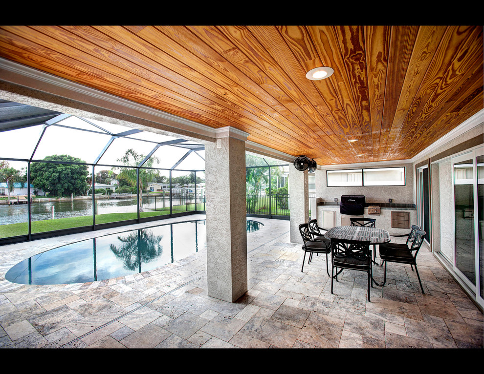 Photo of a mid-sized contemporary backyard kidney-shaped lap pool in Tampa with tile.